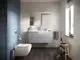 Moderne Badezimmeransicht mit blauer Wandfliese, Waschtisch in hellem Design und Spiegel. Ideal Standard Sanitäranlage mit WC und Handtuchhalter in minimalistischer Umgebung.